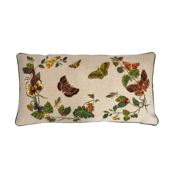 A rectangular cotton lumbar pillow with an embroidered butterfly and flower design on a beige mud cloth background, featuring green piping around the edges.